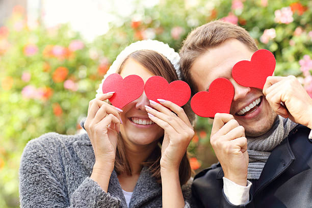 istock Happy couple covering eyes with hearts 636081392