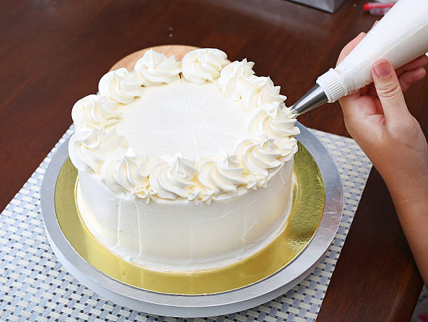 istock Cake in process on stand on wooden table, Homemade Cake. 636082384