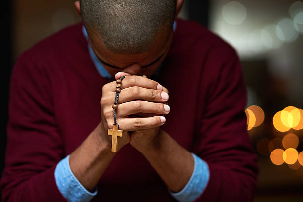 He'll answer all your prayers Cropped shot of a man holding a rosary and praying rosary beads stock pictures, royalty-free photos & images