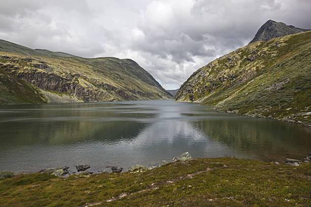 istock Calm mountain lake over the rocky slopes 636087256