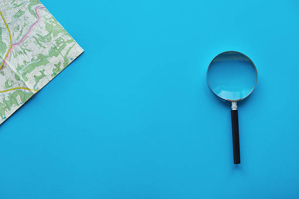 High angle view of map and magnifying glass
