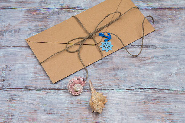 istock Kraft envelope with ornaments in marine style on wooden background 636098140