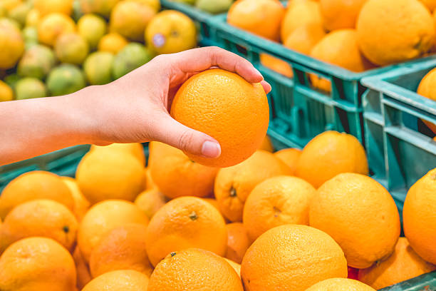 istock Closeup image of a woman selecting oranges 636098314