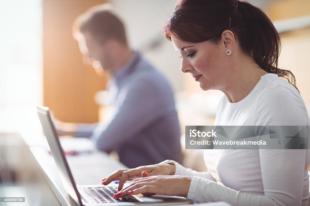 Mature student using laptop Mature student using laptop in the classroom Computer Lab Stock Photo