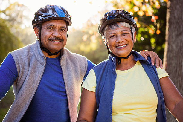 ritratto di coppia matura con casco da ciclismo - mature adult bicycle senior adult heterosexual couple foto e immagini stock