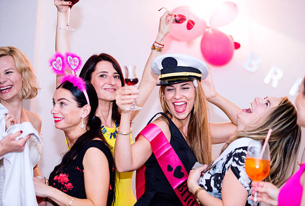 Cheerful bride and bridesmaids celebrating hen party with drinks Cheerful bride and happy bridesmaids celebrating hen party with drinks. Women enjoying a bachelorette party dancing. bachelorette party stock pictures, royalty-free photos & images