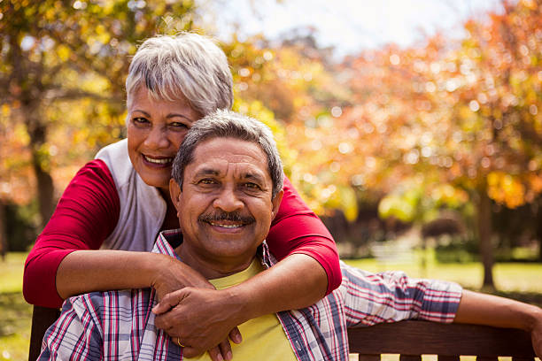 istock An elderly woman hugs her husband sitting on the bench 636102128