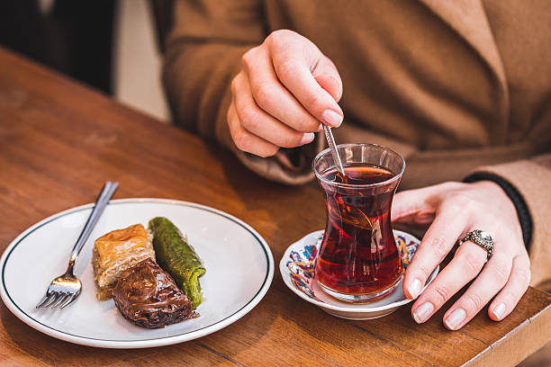 Traditional tea with turkish delights. Woman's hand stirs sugar