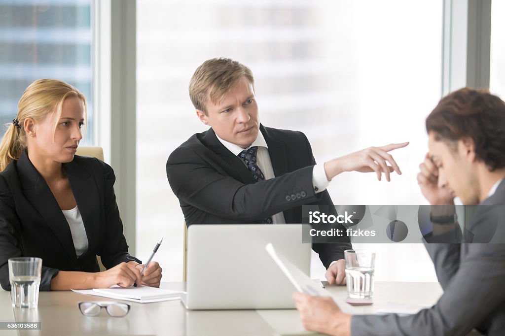 Client firing incompetent contractor Furious client scolding, firing incompetent contractor after unproductive work results. Young frustrated businessman receiving dismiss notification from his partner for incompetence Arguing Stock Photo
