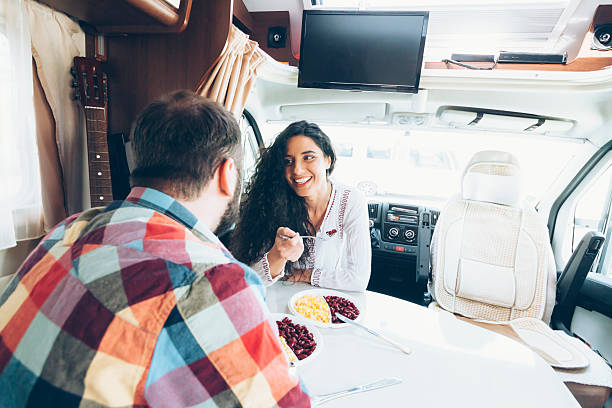 istock Couple having fun and dining inside of caravan 636103664