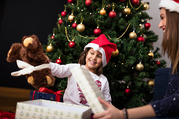 istock Happy little girl is opening her Christmas present 636105256