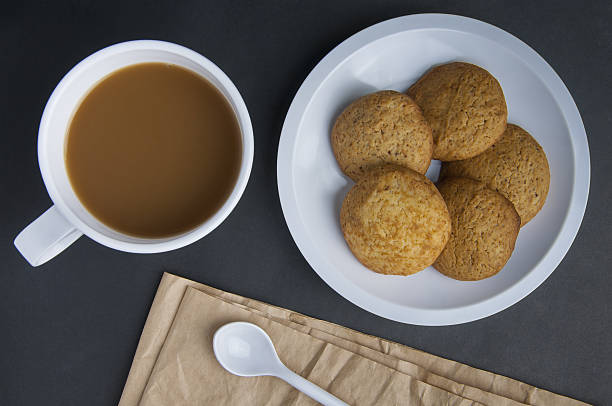 istock white coffee cup and cookie on black bankgrounds 636105320