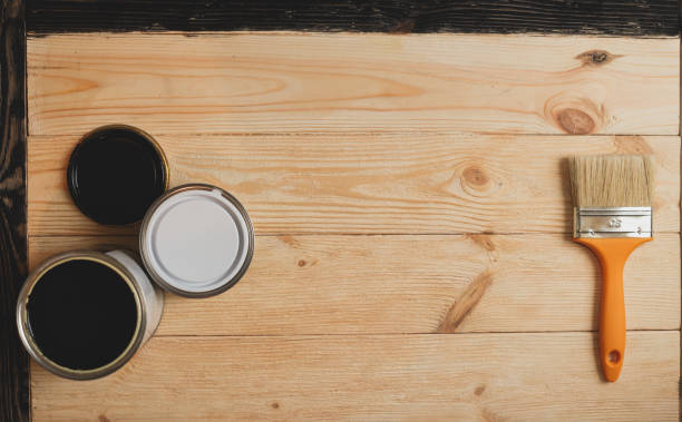 istock Two paint tins and brush on wooden background with copy 636105632