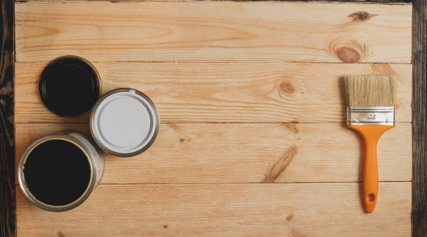 istock Two paint tins and brush on wooden background with copy 636105772