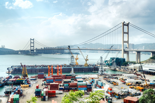 Cargo freight ship with working crane in shipyard Singapore