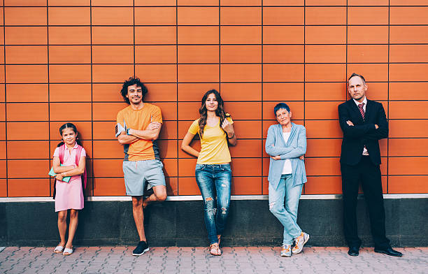 Different generations Five people at different ages standing agains a wall seperately. family photo on wall stock pictures, royalty-free photos & images