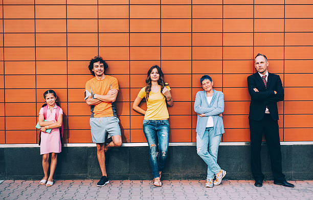 Different generations Five people at different ages standing agains a wall seperately. unique family stock pictures, royalty-free photos & images