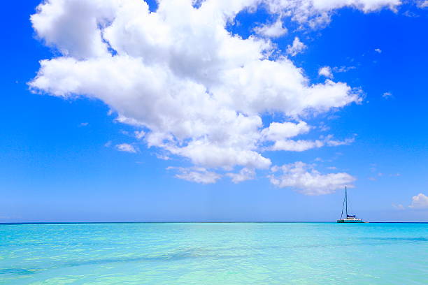 tropical paradise: turquoise caribbean sea, yacht sailing under dramatic sky - moody sky water sport passenger craft scenics imagens e fotografias de stock