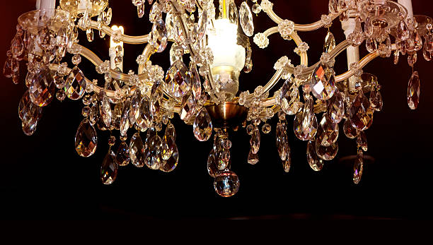 istock Beautiful crystal chandelier on black ceiling 636117450