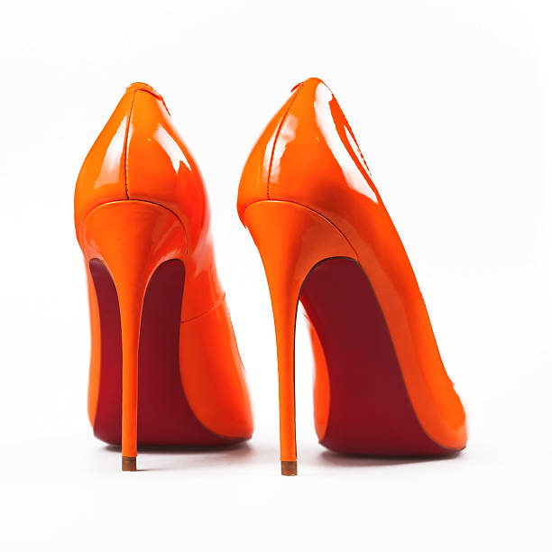 istock Female orange shoes over white 636117536