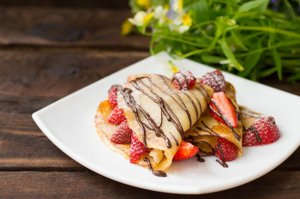 istock Pancakes with strawberries, topped  chocolate. Wooden table. Top view 636117882