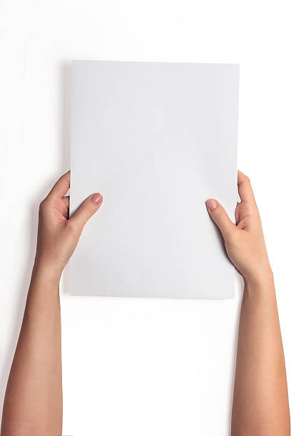 istock Hand holding white blank paper sheet mockup, isolated. Arm hold 636118288