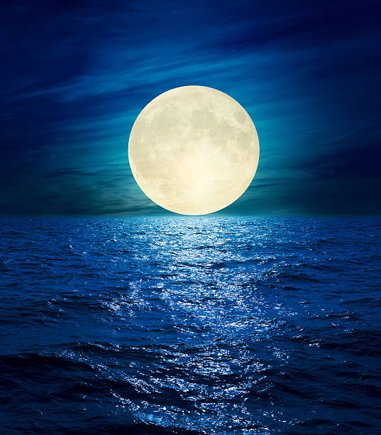 istock big moon in clouds over night sea 636118300