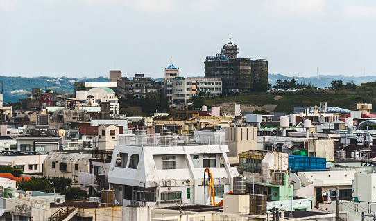 Okinawa, Japan - March 30, 2015: Urban cityscape across the city of Naha in Okinawa with hospital buildings on the hill in the distance
