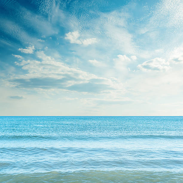istock dark sky with clouds over blue sea in sunset 636119800