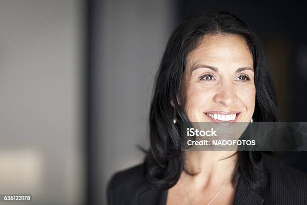 Mature Spanish Businesswoman Smiling And Looking Away At The Office Stock Photo - Download Image Now