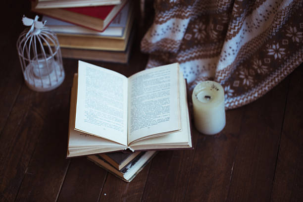 istock Stack of books with warm plaid on chair 636134364