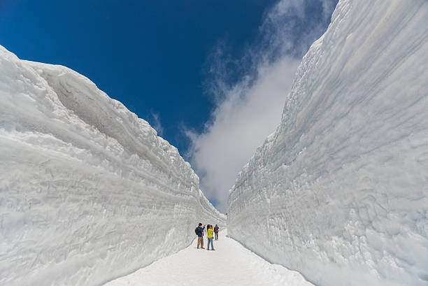 Snow wall Tateyama, Japan - May 2, 2014: Unidentified tourists visit at snow wall on Tateyama Kurobe Alpine Route, Japanese Alps in Tateyama, Japan japanese snowboarder stock pictures, royalty-free photos & images