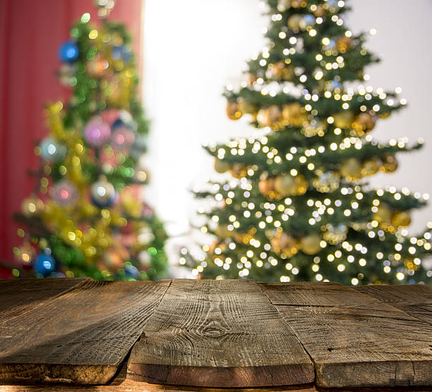 istock christmas table background with christmas tree out of focus 636139732