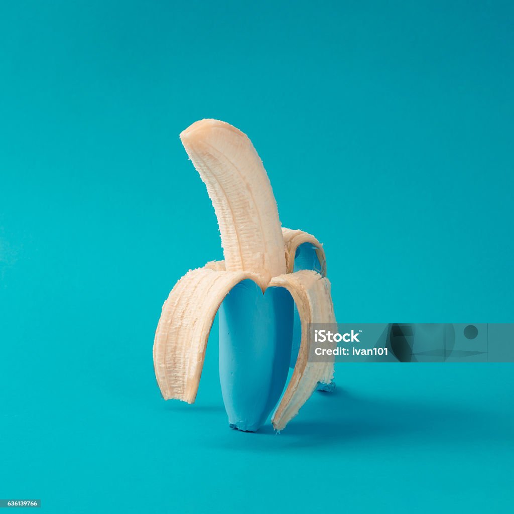 Painted blue peeled banana. Minimal concept. Banana Stock Photo