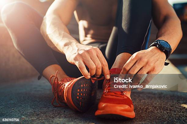 Jogger Tying Shoe Before Jogging Stock Photo - Download Image Now - Men, Running, Athlete