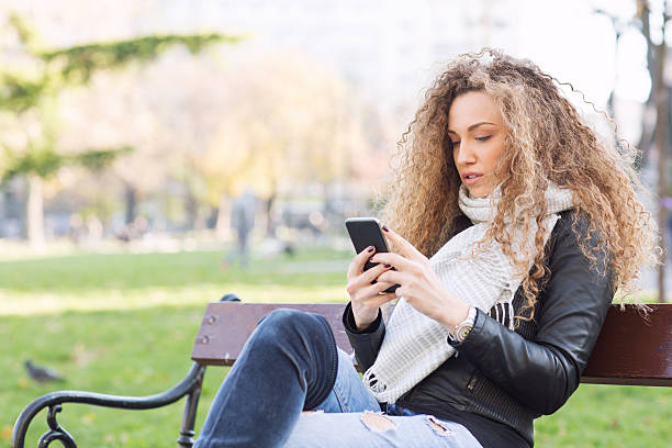 istock Outdoors, young woman with smart phone 636148166