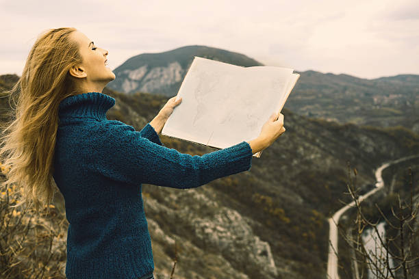 istock Woman on the hill holding atlas map. 636152438
