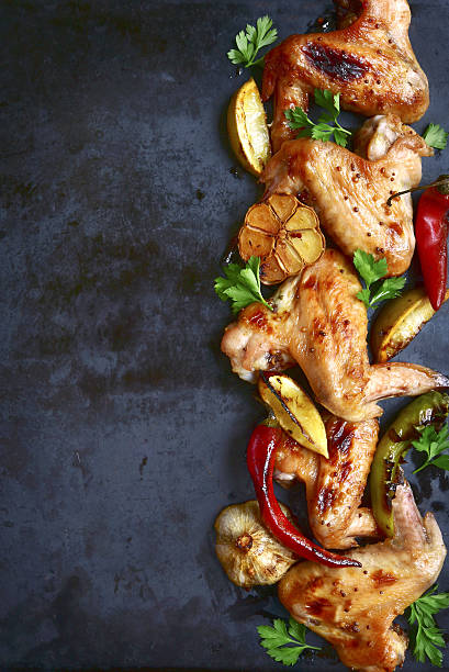istock Grilled chicken wings on a black metal tray.Top view. 636158746