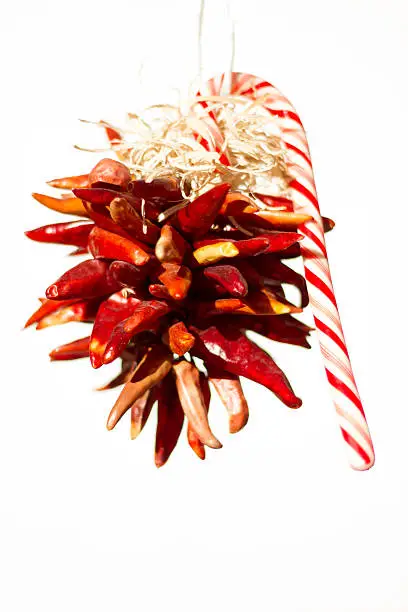 Santa Fe Christmas style: chili pepper ristra and candy cane decoration against a white background with plenty of copy space.