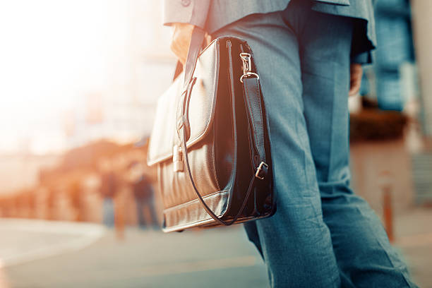 Close up of businessman holding a briefcase Cropped view of businessman holding a briefcase outdoors briefcase stock pictures, royalty-free photos & images