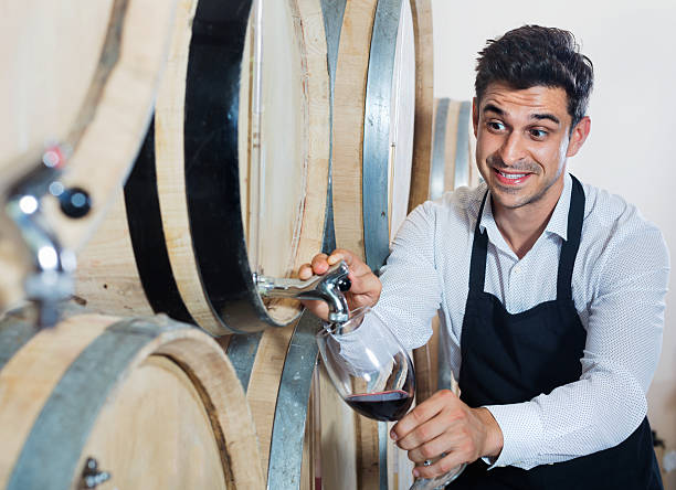 istock Man pouring red wine into glass in alcohol section 636163622