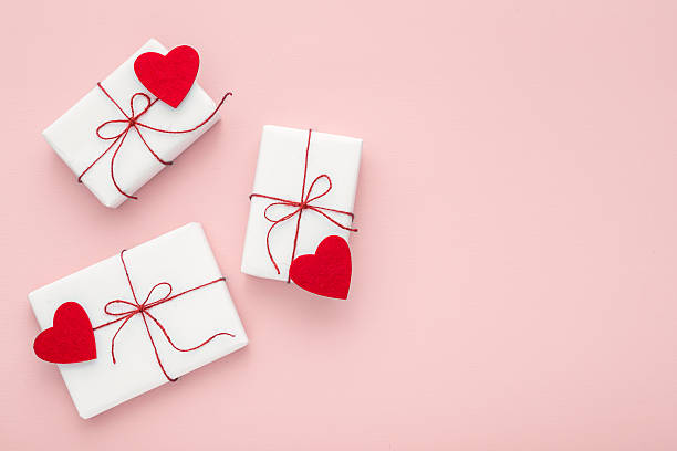 Valentine day composition: white gift boxes, felt hearts, copy space. Valentine day composition: white gift boxes with bow and red felt hearts, photo template, background. Top View. View from above. coupon photos stock pictures, royalty-free photos & images