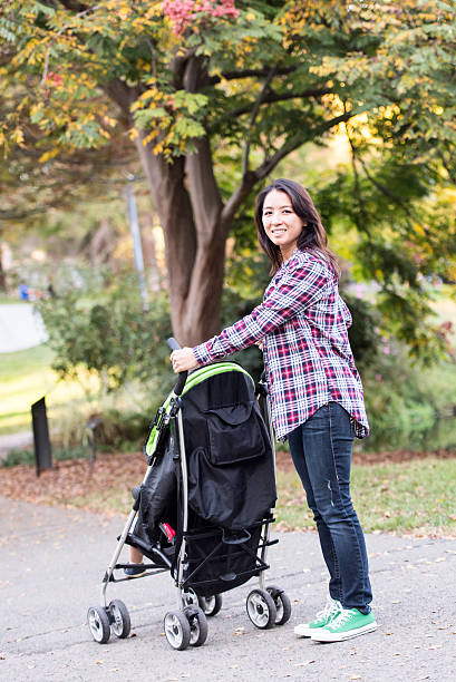istock Asian woman pushing her baby stroller 636165540