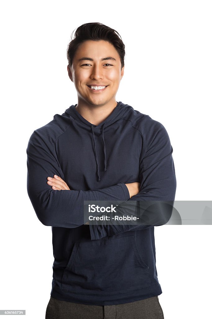 Handsome man in hood sweater An attractive man in his 20s standing against a white background wearing a blue hood shirt smiling, looking at camera. Men Stock Photo