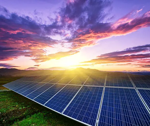 Photo of solar panels  under blue sky on sunset