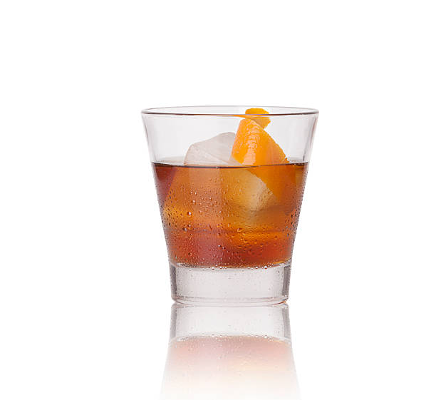Manhattan Drink Manhattan drink in a rocks glass single ice cube and orange peel garnish on a white background vermouth stock pictures, royalty-free photos & images
