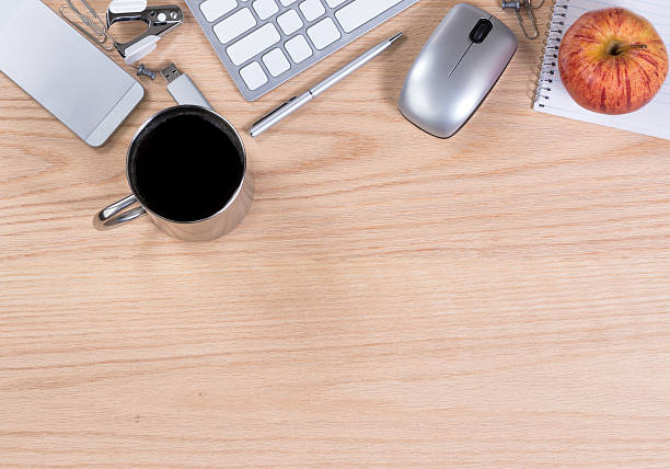 istock Oak wooden desktop with various office equipment on upper border 636169678