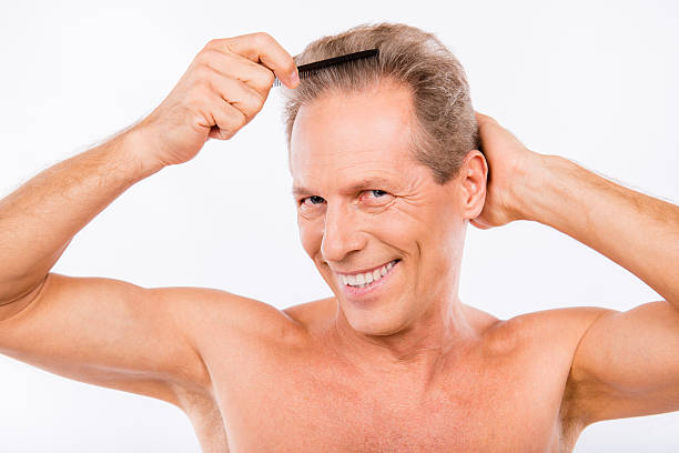 istock Handsome man with comb making his hairdress 636171436