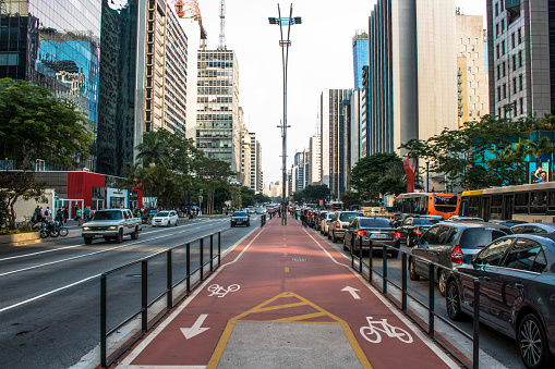 Sao Paulo, Brazil, December 02, 2016. Traffic on avenue and view of bicycle path in Paulista Avenue. This is one of the most important thoroughfares of the city of Sao Paulo, one of the main financial centers of the city
