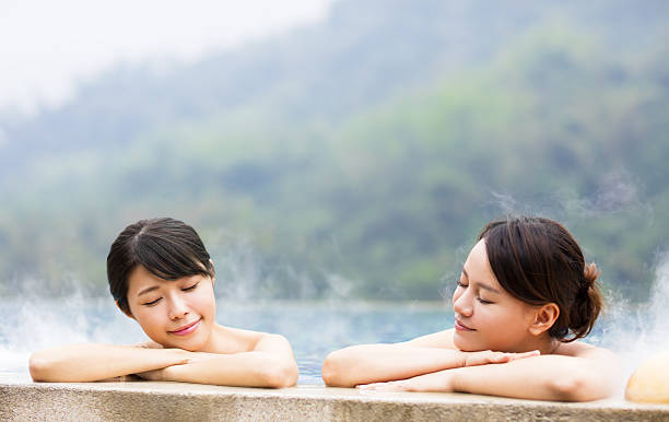 温泉でリラックスして幸せな若い女性 - 温泉 ストックフォトと画像